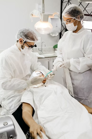 a dentist and dental assistant performing dental cleaning