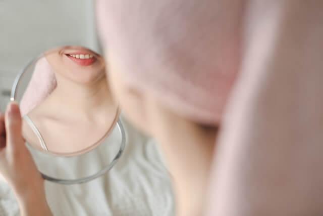 a smiling woman's reflection in the mirror