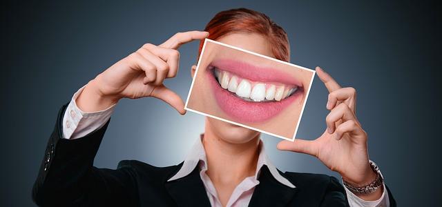 a woman in business attire holding a close-up shot of a nice set of teeth