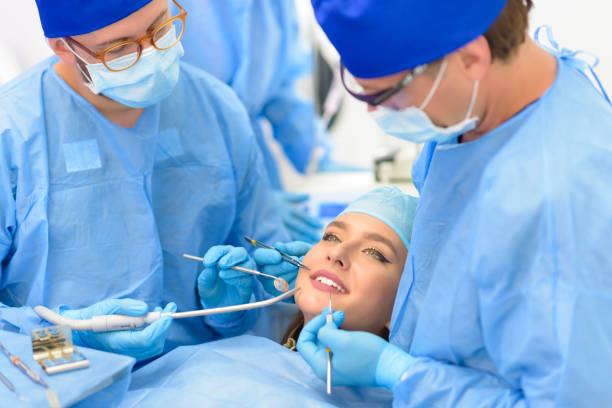 two dental professionals performing a dental treatment to a patient